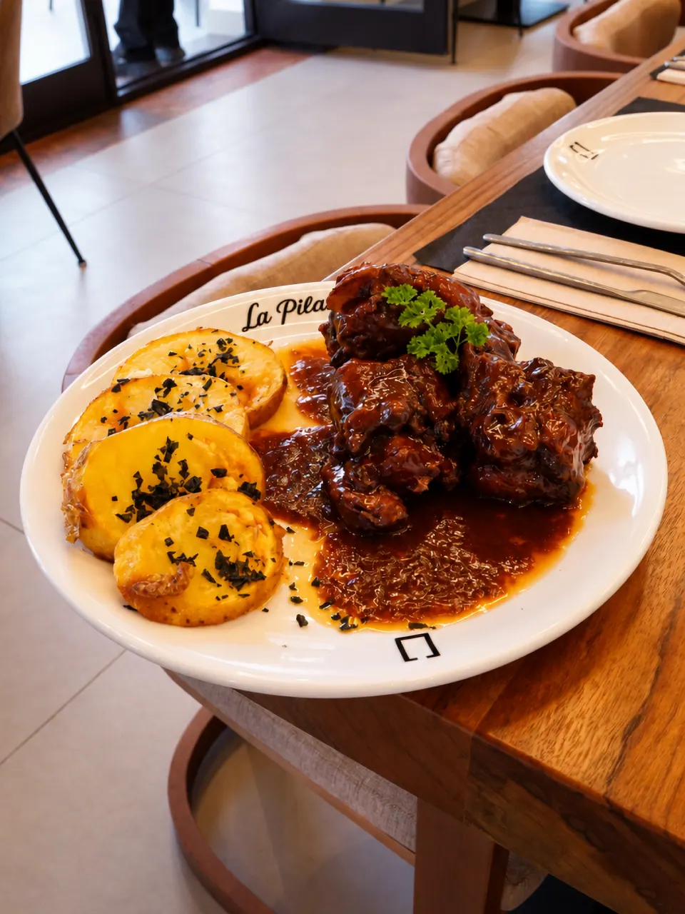 Guiso de carne con salsa oscura servido en La Pilastra
