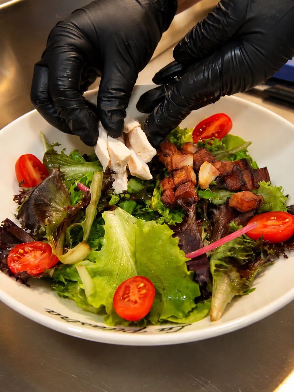 Ensalada César terminándose con brotes y tomates cherry en La Pilastra
