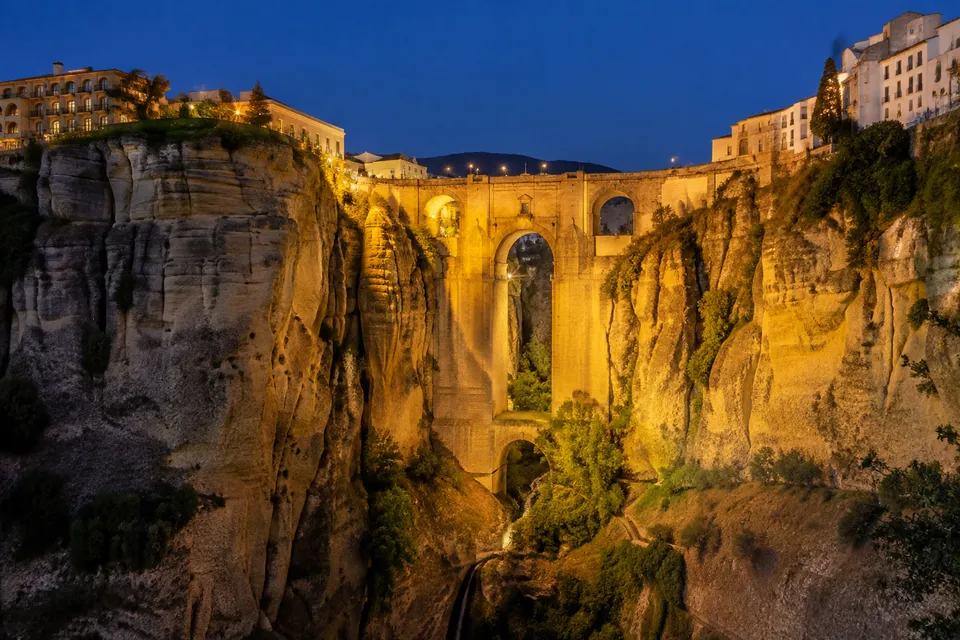 Puente Nuevo iluminado de noche sobre el Tajo oscuro